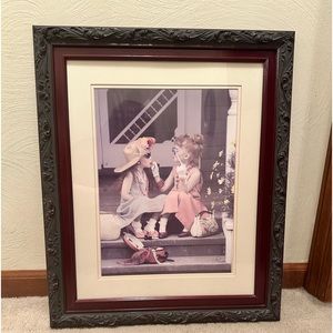 Picture of young girls playing dress up framed in dark wood. Size 20” x 24”.